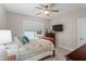 Bedroom with a ceiling fan, TV, and a large window overlooking the backyard at 958 Bay Bouquet Ln, Apex, NC 27523