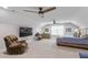 A large bonus room features two ceiling fans, sitting area, piano, and neutral color palette at 958 Bay Bouquet Ln, Apex, NC 27523