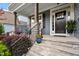 Inviting front porch with stone steps, decorative plants, and elegant architectural details at 958 Bay Bouquet Ln, Apex, NC 27523