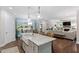 Kitchen island with white farmhouse sink, granite countertops, pendant lighting and view of living and dining area at 958 Bay Bouquet Ln, Apex, NC 27523