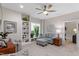 Inviting living room featuring a cozy sofa, accent chairs, a ceiling fan, and built-in shelves with decor at 958 Bay Bouquet Ln, Apex, NC 27523