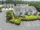 Aerial view of townhomes with manicured lawns, mature trees, and ample parking at 100 Beaconwood Ln, Holly Springs, NC 27540
