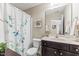 Well-maintained bathroom featuring a vanity, toilet, shower with curtain, and decorative artwork at 100 Beaconwood Ln, Holly Springs, NC 27540
