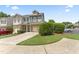 Inviting townhome featuring a manicured lawn, attached garage, and charming curb appeal at 100 Beaconwood Ln, Holly Springs, NC 27540