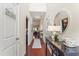 Hallway with wood floors, leading to main living area. Decorative table and artwork enhance the space at 100 Beaconwood Ln, Holly Springs, NC 27540