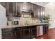 Modern kitchen with stainless steel appliances, granite countertops, and dark wood cabinets at 100 Beaconwood Ln, Holly Springs, NC 27540