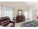 Spacious main bedroom featuring an inviting reading chair, a vaulted ceiling, and soft natural lighting at 100 Beaconwood Ln, Holly Springs, NC 27540