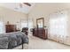Spacious main bedroom featuring a comfy chair, vaulted ceiling, and natural light filtering through sheer curtains at 100 Beaconwood Ln, Holly Springs, NC 27540