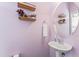 Charming powder room with a stylish pedestal sink, a round mirror, and decorative shelving with floral accents at 100 Beaconwood Ln, Holly Springs, NC 27540