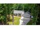 Beautiful aerial shot of home featuring inviting front porch, attached garage, and driveway surrounded by mature trees at 1006 Oxford Ridge Rd, Wake Forest, NC 27587