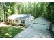 Aerial view of a single-story home with a detached garage, long driveway, and a lush green lawn at 1006 Oxford Ridge Rd, Wake Forest, NC 27587