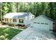 Aerial view of a single-story home with a detached garage, long driveway, and a lush green lawn at 1006 Oxford Ridge Rd, Wake Forest, NC 27587