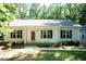 Charming single-story home featuring a welcoming front porch, well-maintained lawn and mature trees at 1006 Oxford Ridge Rd, Wake Forest, NC 27587