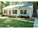 Single-story home featuring a well-manicured lawn, dark shutters, and a welcoming red front door at 1006 Oxford Ridge Rd, Wake Forest, NC 27587