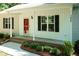 Inviting front porch with a red door, dark shutters, and well-maintained landscaping at 1006 Oxford Ridge Rd, Wake Forest, NC 27587