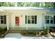 Inviting front porch with a red door, dark shutters, and well-maintained landscaping at 1006 Oxford Ridge Rd, Wake Forest, NC 27587