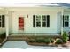 Inviting front porch with a red door, dark shutters, and well-maintained landscaping at 1006 Oxford Ridge Rd, Wake Forest, NC 27587