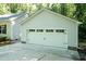 Detached two-car garage with white doors and large driveway at 1006 Oxford Ridge Rd, Wake Forest, NC 27587