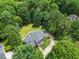 Nestled among mature trees, the property offers a circular driveway, lush landscaping, and serene outdoor living spaces at 1009 Bentham Dr, Raleigh, NC 27614