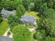 Breathtaking aerial view of a stately home nestled among lush green trees in a tranquil setting at 1009 Bentham Dr, Raleigh, NC 27614