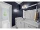 Stylish bathroom with white cabinets, dark blue walls, and modern fixtures at 1009 Bentham Dr, Raleigh, NC 27614