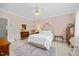 Cozy bedroom with pink walls, natural light, plush carpet, and classic wood furniture at 1009 Bentham Dr, Raleigh, NC 27614