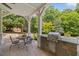 Outdoor kitchen and dining area featuring a built-in grill, stone countertop, and comfortable seating at 1009 Bentham Dr, Raleigh, NC 27614