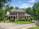 Stately red brick home with manicured landscaping, circular driveway, and covered front porch at 1009 Bentham Dr, Raleigh, NC 27614