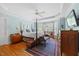 Bright main bedroom with ceiling fan, hardwood floors, four-poster bed, and large windows at 1009 Bentham Dr, Raleigh, NC 27614