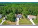 An aerial view showcases a beautiful home with a large driveway and is nestled amongst the tall green trees at 1054 Contender Dr, Clayton, NC 27520