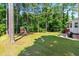 Lush backyard with a playset, swing, hammock and mature trees, perfect for outdoor activities at 1054 Contender Dr, Clayton, NC 27520