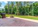 Backyard featuring a stamped patio and playground equipment, surrounded by tall trees, perfect for recreation at 1054 Contender Dr, Clayton, NC 27520