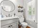 Charming powder room with stylish fixtures, a round mirror, and great natural light at 1054 Contender Dr, Clayton, NC 27520