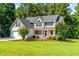 Charming two-story home with a well-manicured lawn, lovely landscaping, and inviting front porch perfect for relaxing at 1054 Contender Dr, Clayton, NC 27520