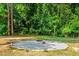 An attractive stone fire pit sits in a gravel bed, perfect for enjoying evenings outdoors among the trees at 1054 Contender Dr, Clayton, NC 27520