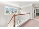 Bright hallway landing with large window, hardwood railing, and neutral carpet at 1054 Contender Dr, Clayton, NC 27520