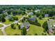 Areal view of a neighborhood with mature trees, lush landscaping, and a lake in the background at 109 Lake Point Dr, Clayton, NC 27527