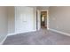 A carpeted bedroom features a closet with double doors and an open doorway to another room at 109 Lake Point Dr, Clayton, NC 27527