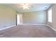 Large bedroom featuring plush carpet, neutral paint, a ceiling fan, and three large windows at 109 Lake Point Dr, Clayton, NC 27527