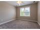 Cozy bedroom featuring neutral walls, plush carpeting, and a bright window at 109 Lake Point Dr, Clayton, NC 27527