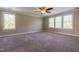 Light streams into the carpeted bedroom through multiple windows, highlighting its comfortable space at 109 Lake Point Dr, Clayton, NC 27527