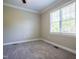 A bright bedroom featuring neutral carpeting and a well-lit window at 109 Lake Point Dr, Clayton, NC 27527