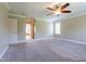 A spacious carpeted bedroom with ceiling fan, window and doorway to bathroom with tub at 109 Lake Point Dr, Clayton, NC 27527