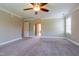 A spacious carpeted bedroom with ceiling fan and natural light from a window at 109 Lake Point Dr, Clayton, NC 27527