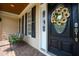 Close-up of the front door with an oval window, decorative wreath and seating at 109 Lake Point Dr, Clayton, NC 27527