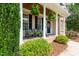 Charming front porch with classic columns, seating, and decorative hanging plants at 109 Lake Point Dr, Clayton, NC 27527