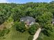 Aerial view showcases a beautiful home nestled amidst lush greenery, emphasizing privacy and a spacious lot at 109 San Juan Dr, Chapel Hill, NC 27514
