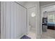 Bright bathroom showing tub/shower with curtain, toilet room with round window, and a bedroom beyond at 109 San Juan Dr, Chapel Hill, NC 27514