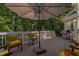 Large wooden deck with seating, sun umbrella, grill, and surrounding trees at 109 San Juan Dr, Chapel Hill, NC 27514