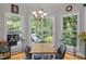 Sunlit dining area featuring a chandelier, three large windows, and seating for four at 109 San Juan Dr, Chapel Hill, NC 27514